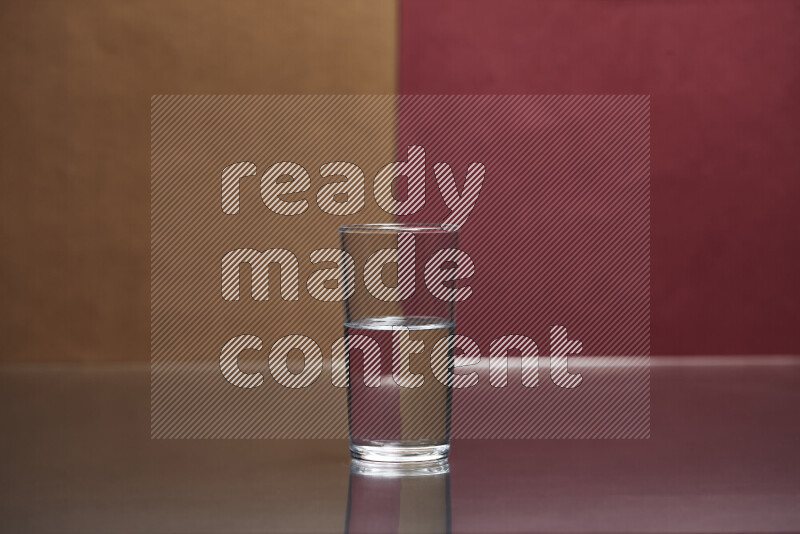 The image features a clear glassware filled with water, set against brown and dark red background