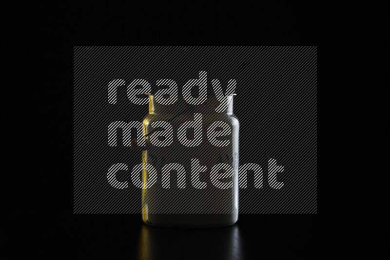 A vintage milk canister with colored rim light against black background