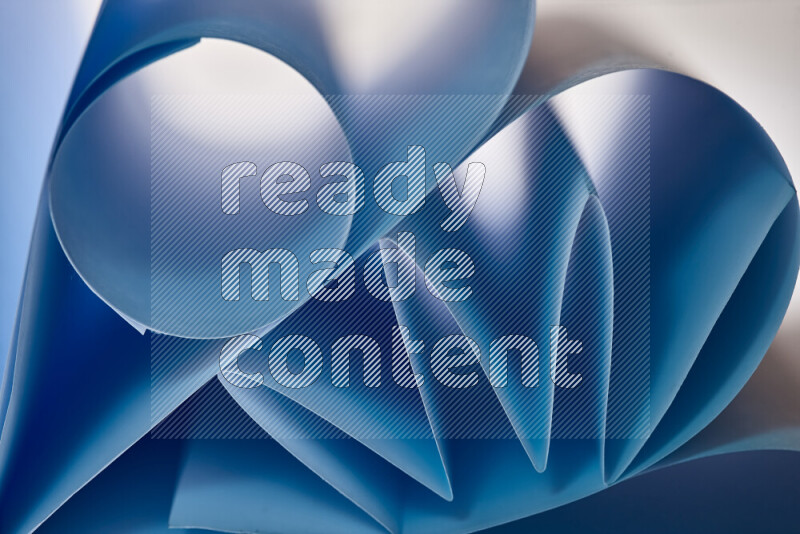 عرض فني لطيات الورق تخلق مزيج من الأشكال الهندسية، مضاءة بإضاءة ناعمة بدرجات اللون الأزرق