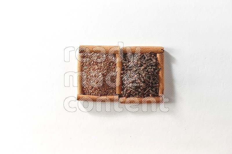 2 squares of cinnamon sticks full of cloves and flaxseeds on white flooring