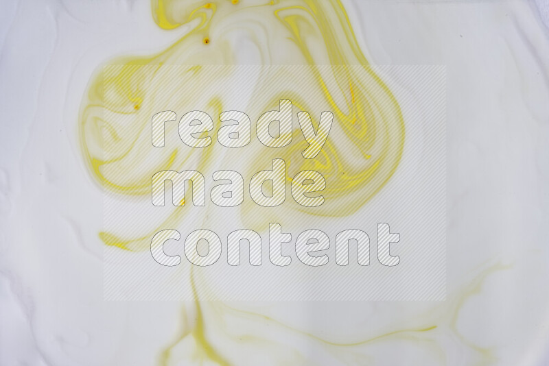 A close-up of abstract swirling patterns in yellow and white