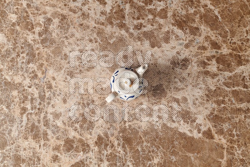 Top View Shot Of A Pottery Teapot On beige Marble Flooring
