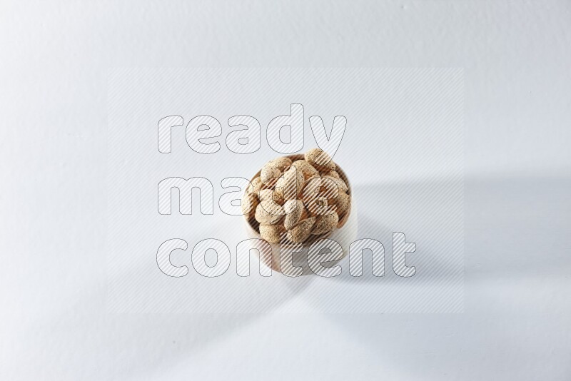A beige ceramic bowl full of almonds on a white background in different angles