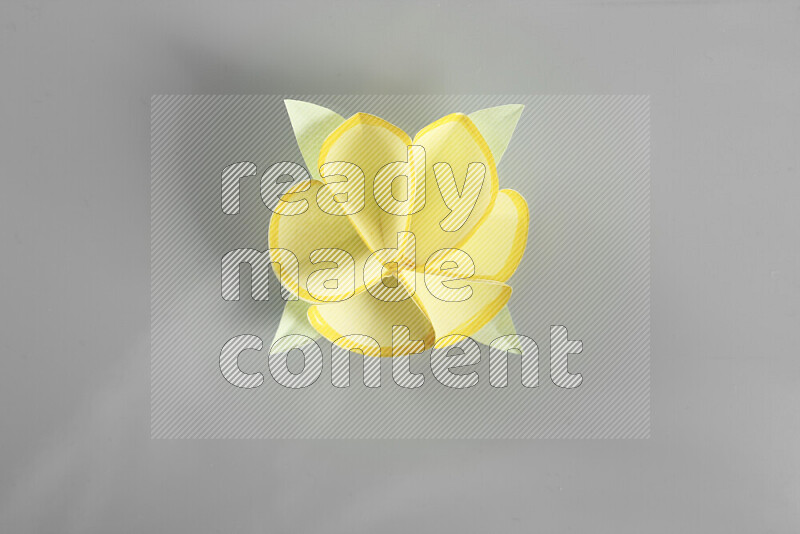 Origami flower on grey background