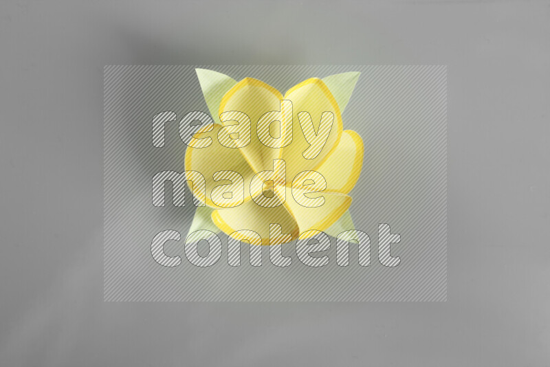 Origami flower on grey background