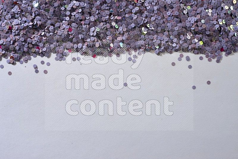 Multicolored flat sequins on grey background