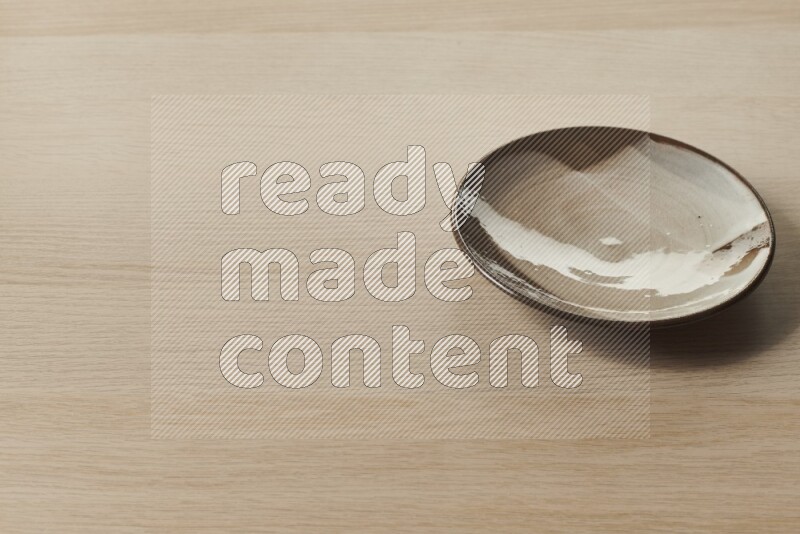 صحن فخاري متعدد الألوان على خلفية خشبية فاتحة