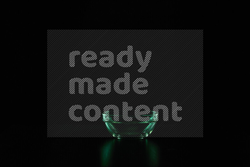 Glassware with rim light in green against black background