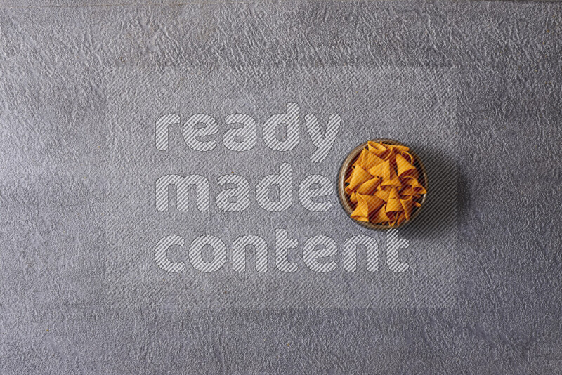 Assorted snacks in pottery bowls on grey background