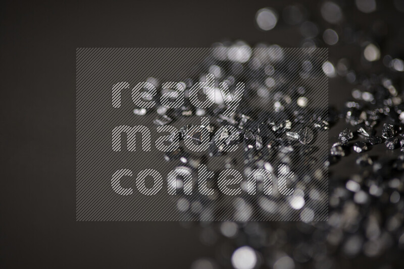 قطع زجاجية سوداء لامعة متناثرة على خلفية سوداء