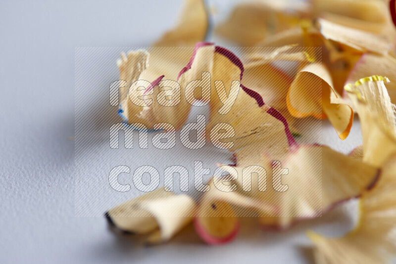 صورة مقربة تظهر كومة صغيرة من نشارة الأقلام ذات حواف ملونة متنوعة علي خلفية رمادية