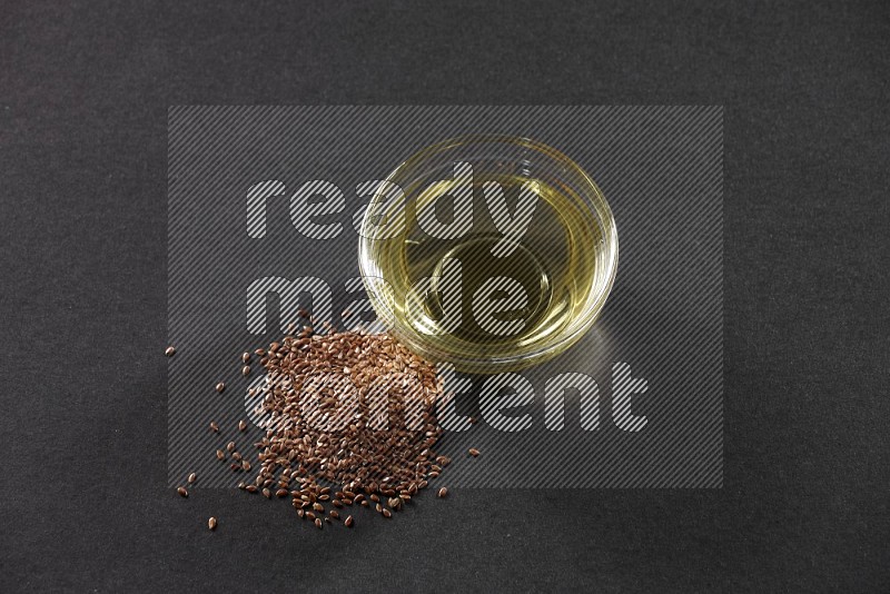 A glass bowl full of flax oil and flax beside it on a black flooring in different angles