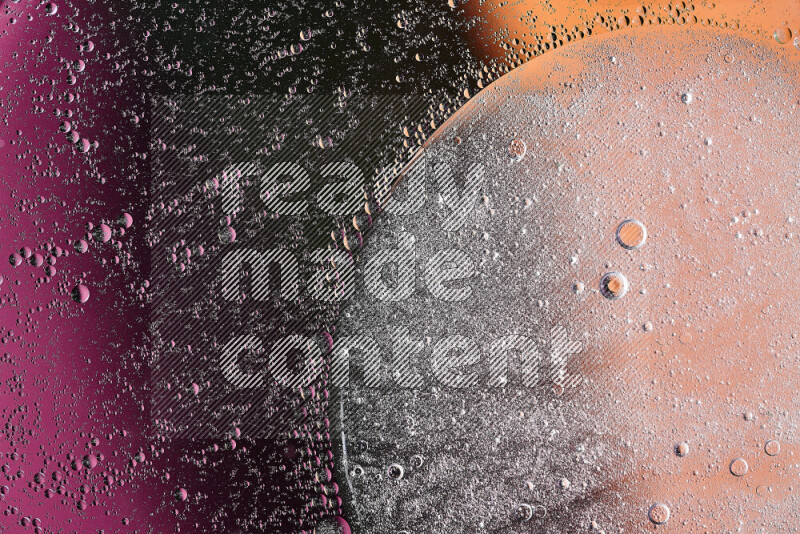 Close-ups of abstract oil bubbles on water surface in shades of black, orange and pink