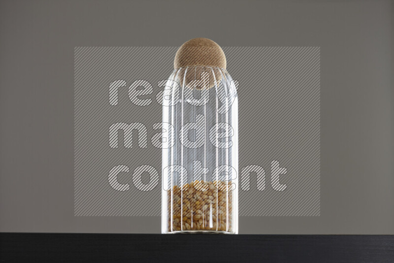Pop corn in a glass jar on black background