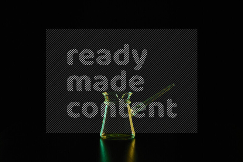 Glassware with rim light in green and yellow against black background