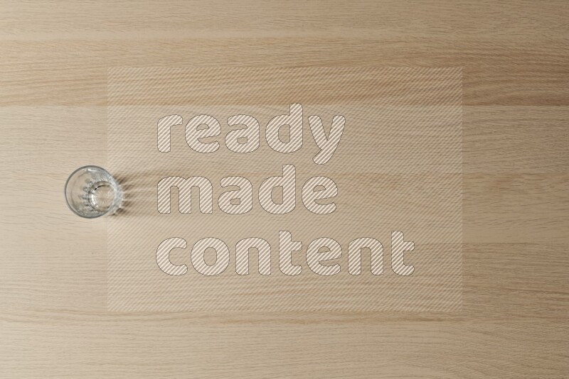 كوب زجاجي فارغ على خلفية خشبية فاتحة