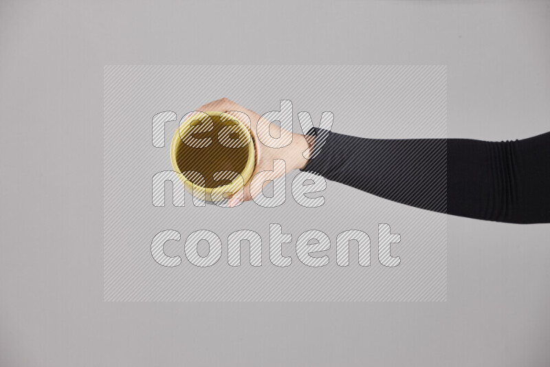 A woman in black abaya holding different pottery essentials in different positions