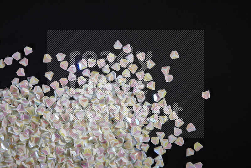 Colorful plastic shards for decoration scattered on a black background