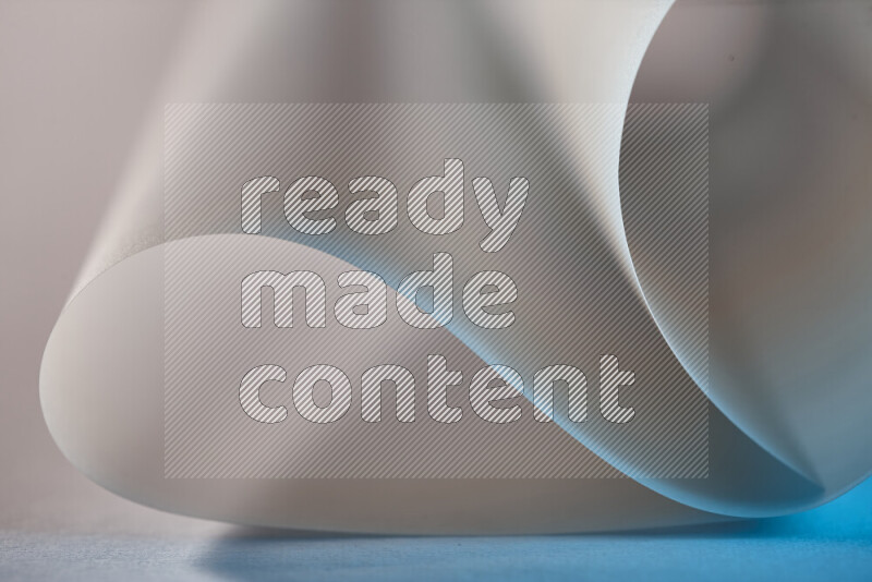 An abstract art piece displaying smooth curves in blue and grey gradients created by colored light