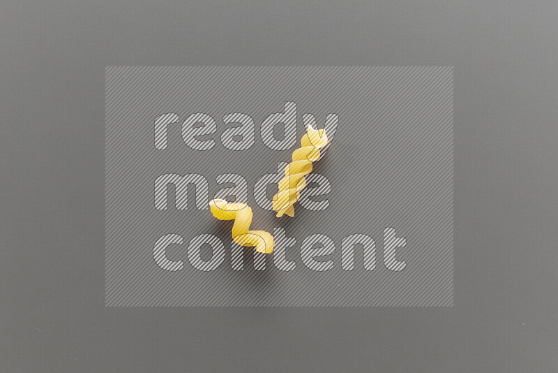 Twist pasta with other types of pasta on grey background