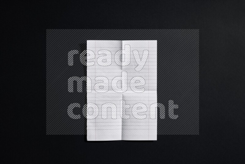 Folded notebook sheet on black background
