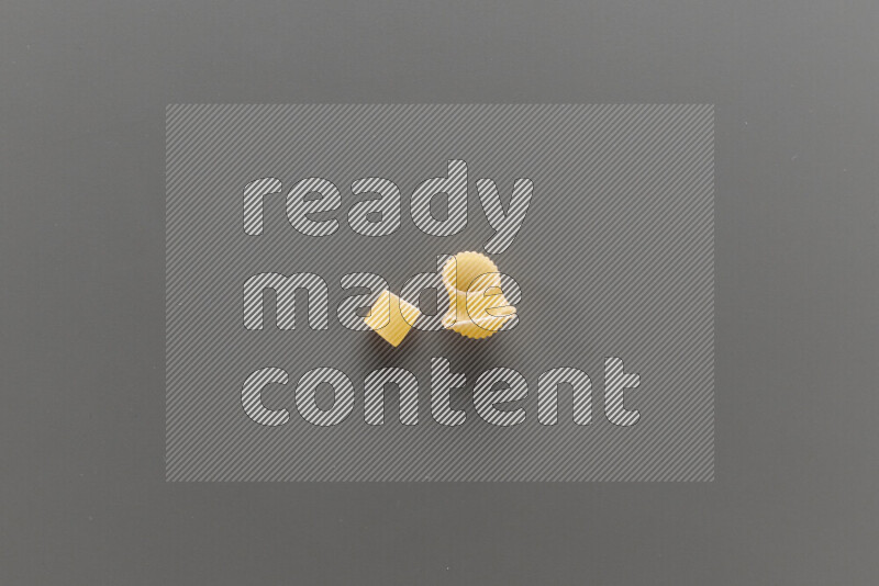 Big rings pasta with other types of pasta on grey background