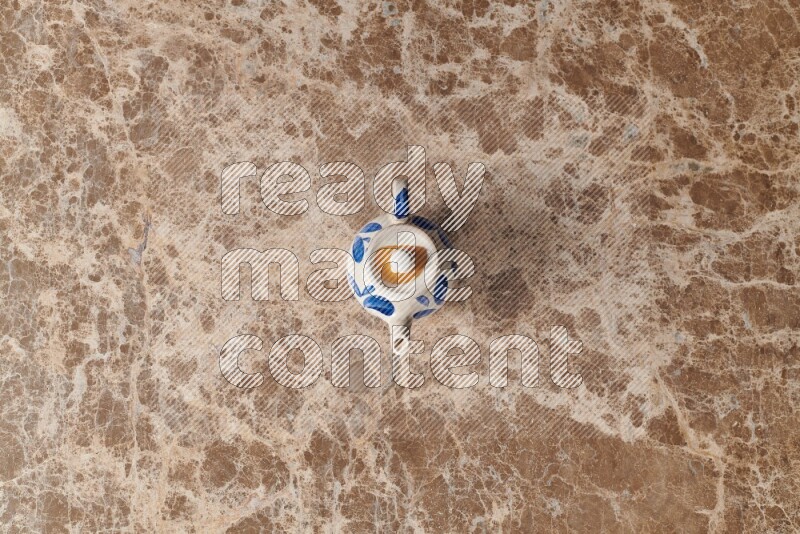 A pottery teapot on beige marble background