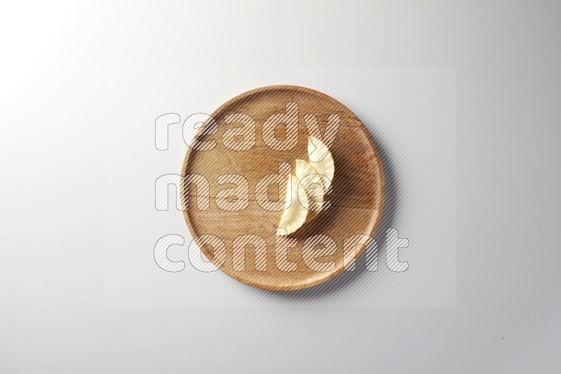 Three Sambosas on a wooden round plate on a white background