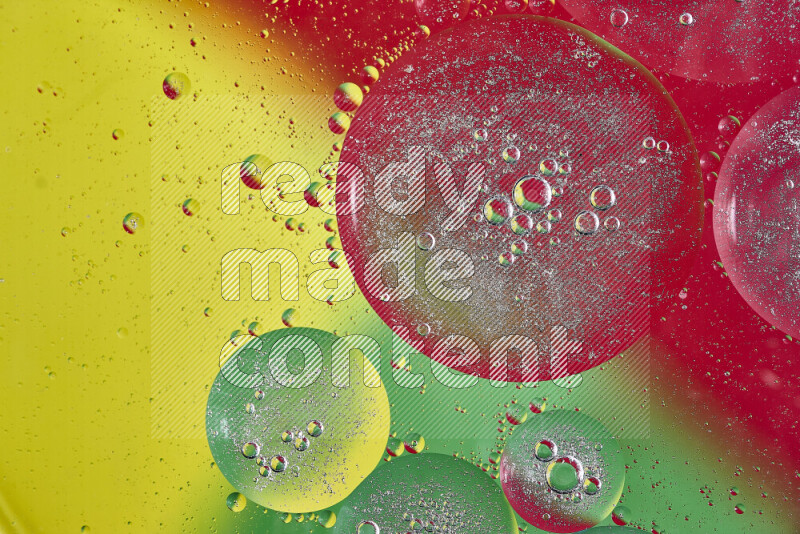Close-ups of abstract oil bubbles on water surface in shades of yellow, green and red
