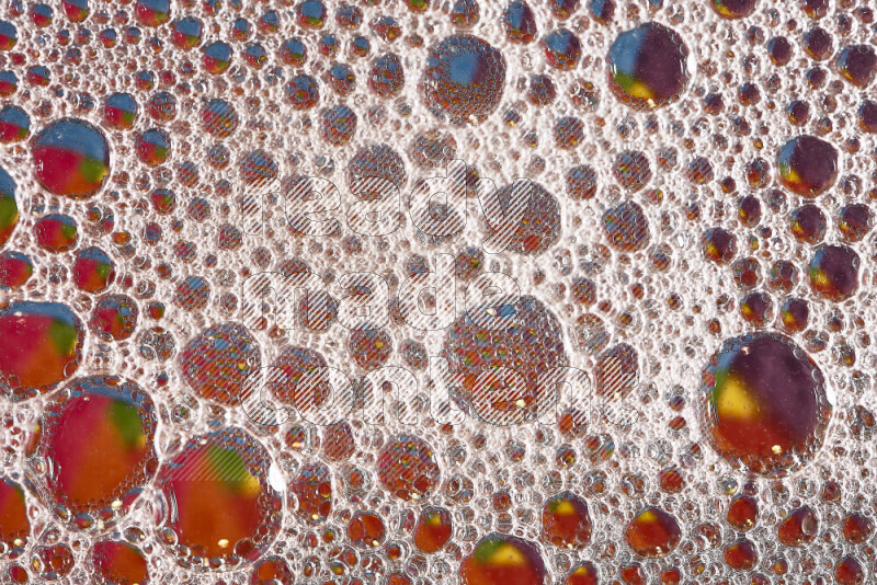 Close-ups of abstract soap bubbles and water droplets on multicolored background