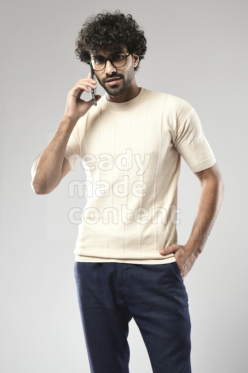 رجل يرتدي ملابس كاجوال يتحدث في الهاتف علي خلفية بيضاء