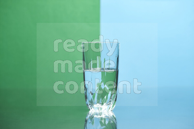 The image features a clear glassware filled with water, set against green and light blue background