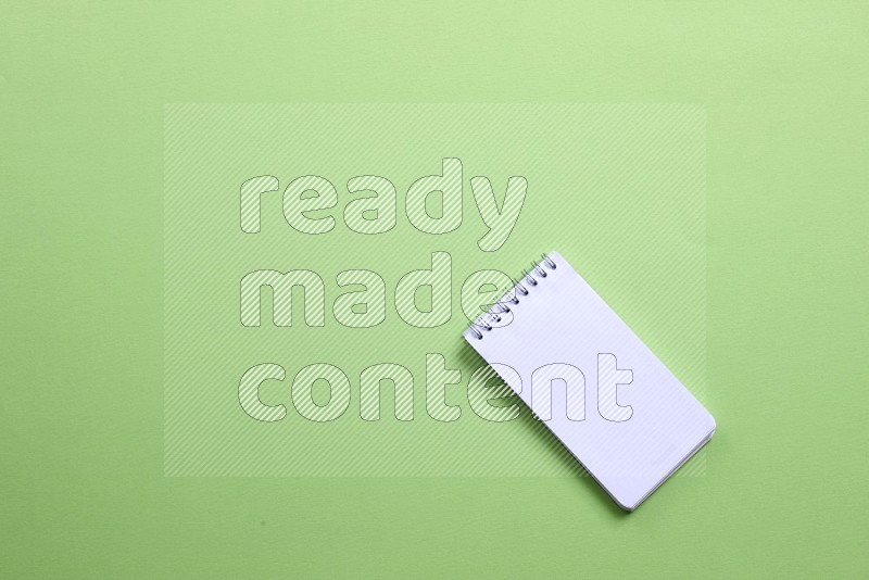 A blank open notebook on green background (back to school)