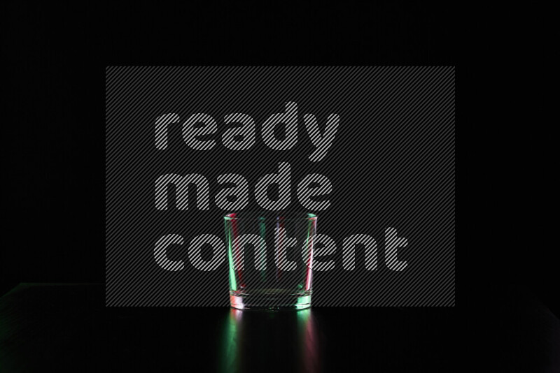 Glassware with rim light in red and green against black background