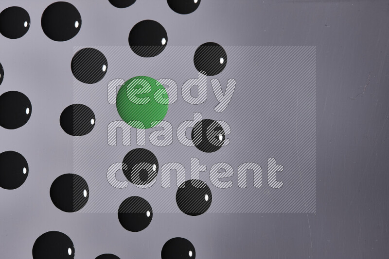 Close-ups of abstract green and black paint droplets on the surface