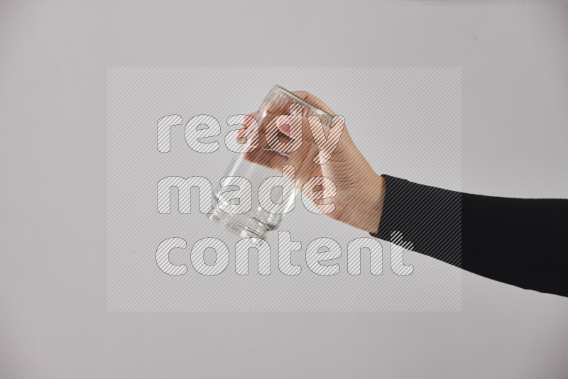 A woman in black abaya holding different glassware in different positions