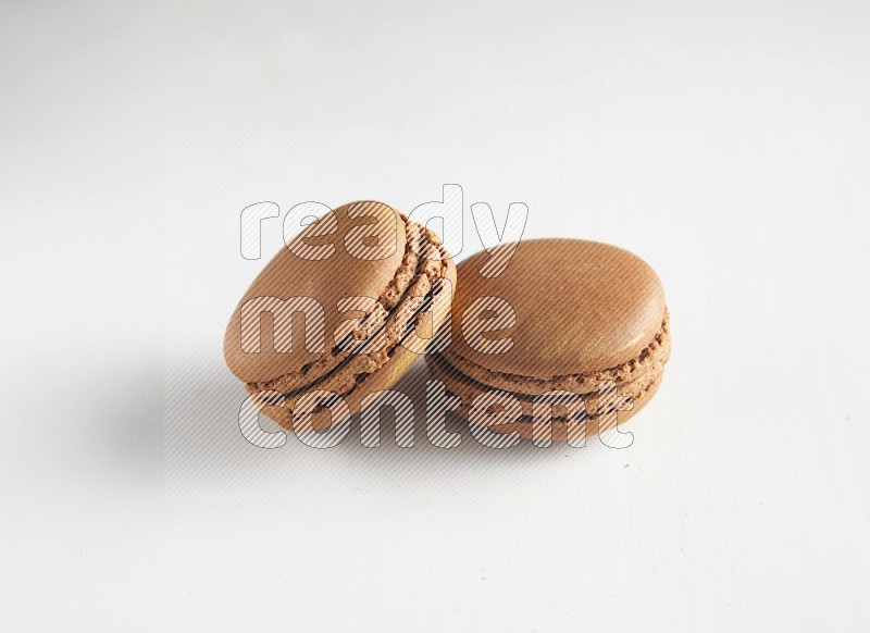 45º Shot of two Brown Coffee macarons on white background