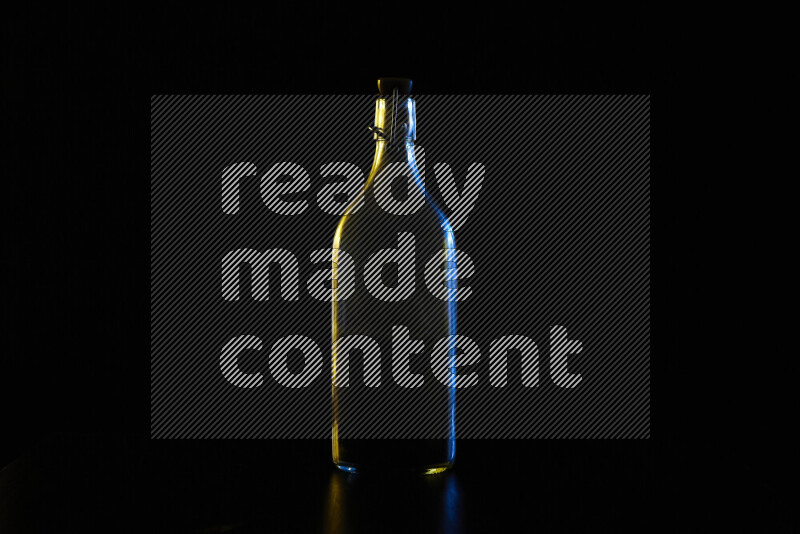 Water bottle with colored rim light against black background