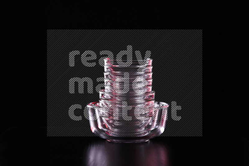 Glassware with rim light in red and white against black background