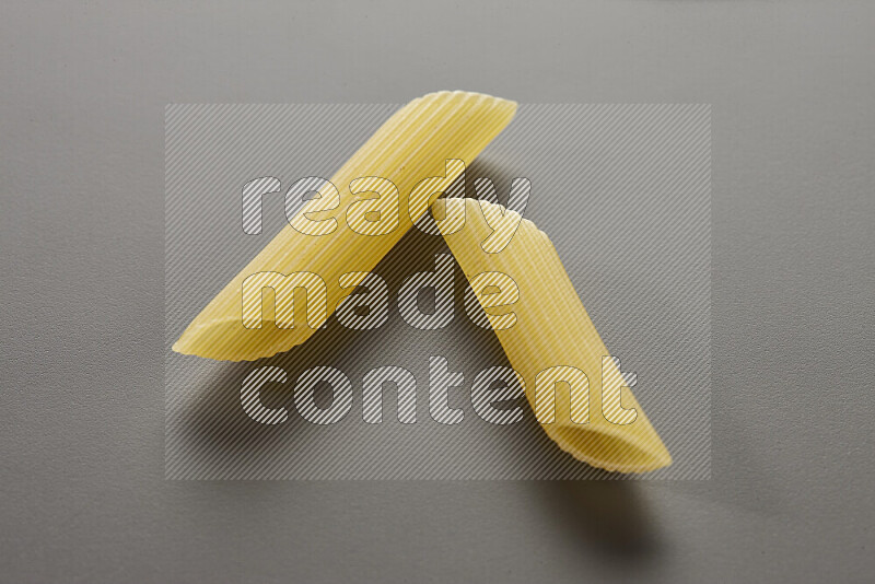 Penne pasta on grey background