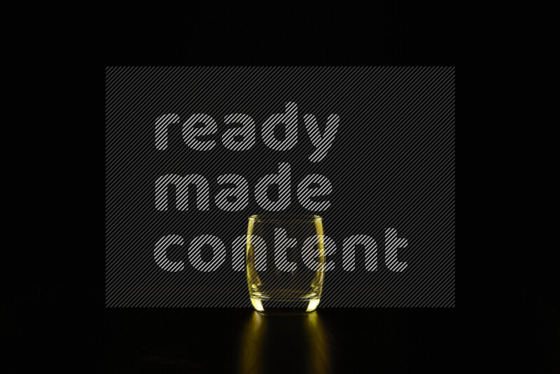 Glassware with rim light in yellow against black background