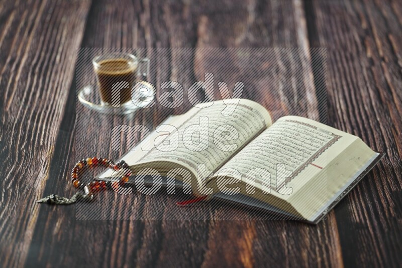 Quran with dates, prayer beads and different drinks all placed on wooden background