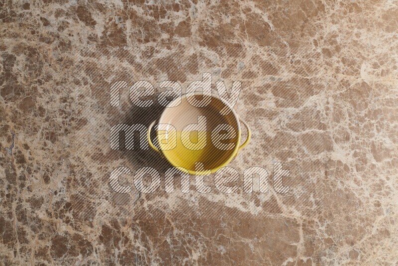 A multicolored pottery bowl on beige marble background