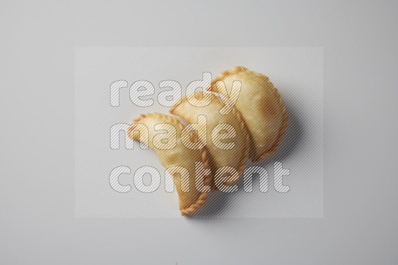 Three fried sambosa from a top angle on a white background