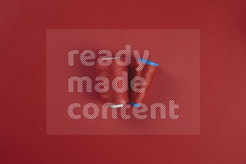 مجموعة من أدوات الخياطة والتفصيل حمراء اللون على خلفية حمراء