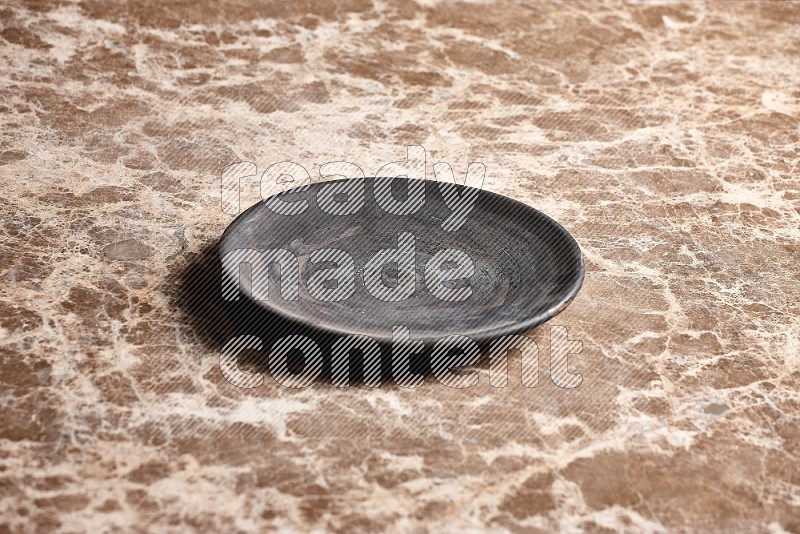 Black Pottery Plate on Beige Marble Flooring, 45 degrees