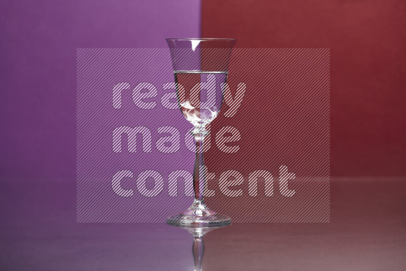 The image features a clear glassware filled with water, set against purple and dark red background