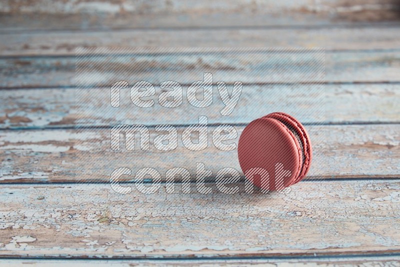 45º Shot of Pink Raspberry macaron on light blue wooden background