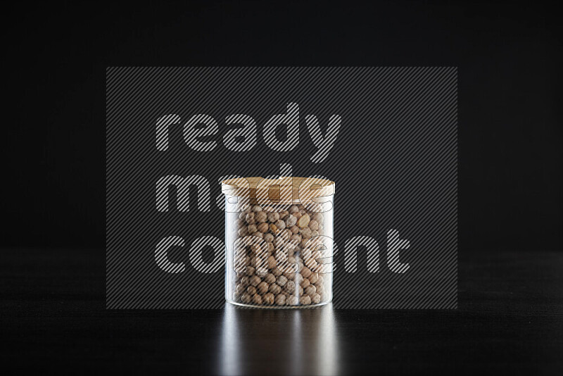 Chickpeas in a glass jar on black background