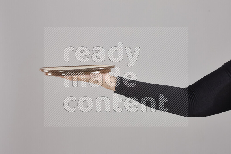 A woman in black abaya holding different pottery essentials in different positions